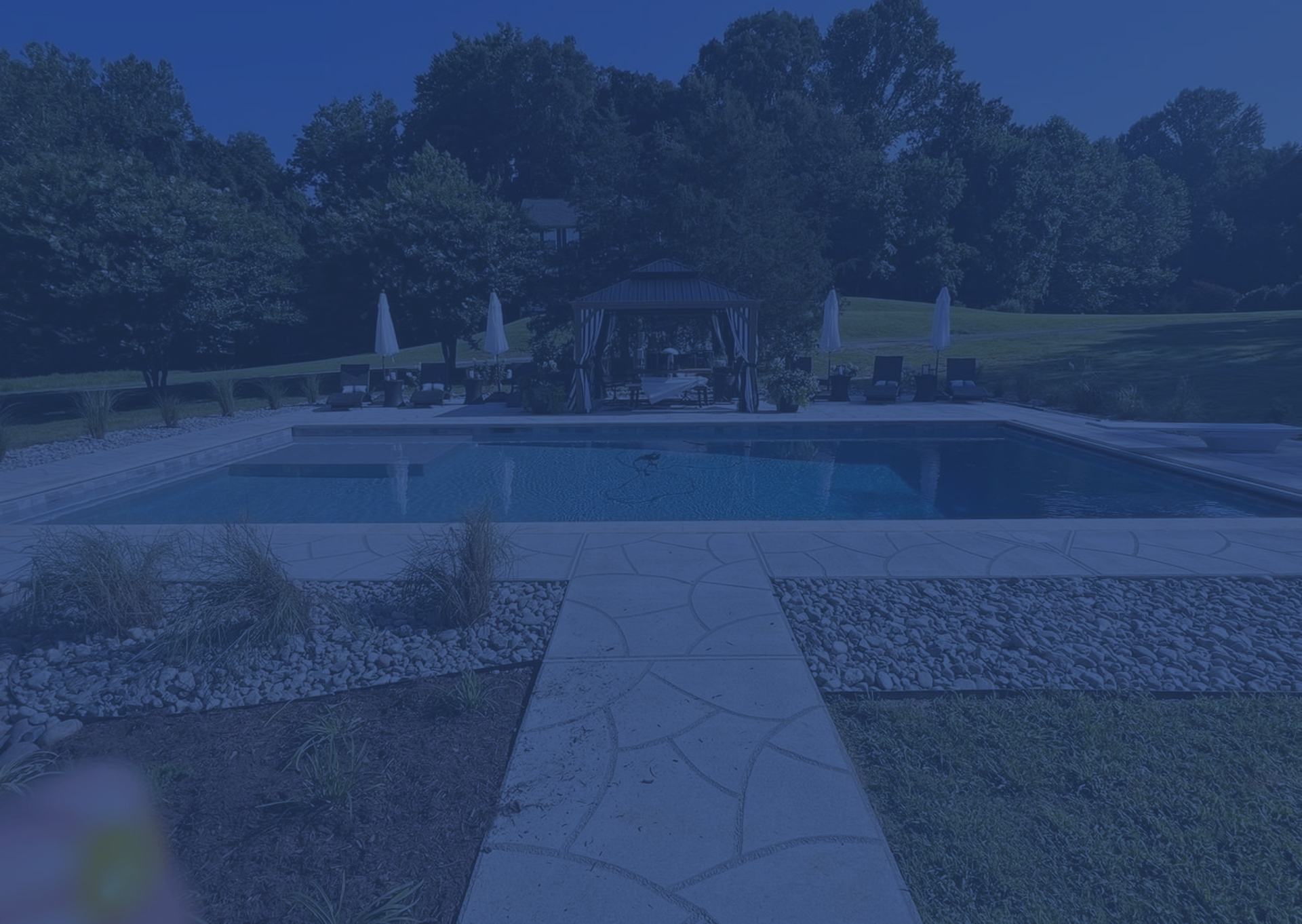 Aerial view of a suburban brick house with a fenced backyard and swimming pool.